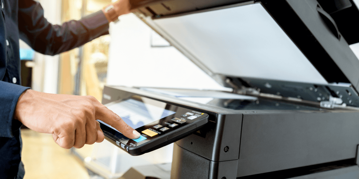 man hand pressing button on panel of printer